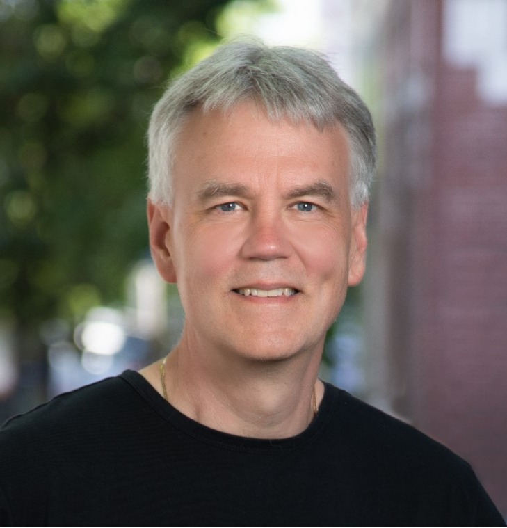 Casual headshot of Antony Barton wearing a black t-shirt and smiling.