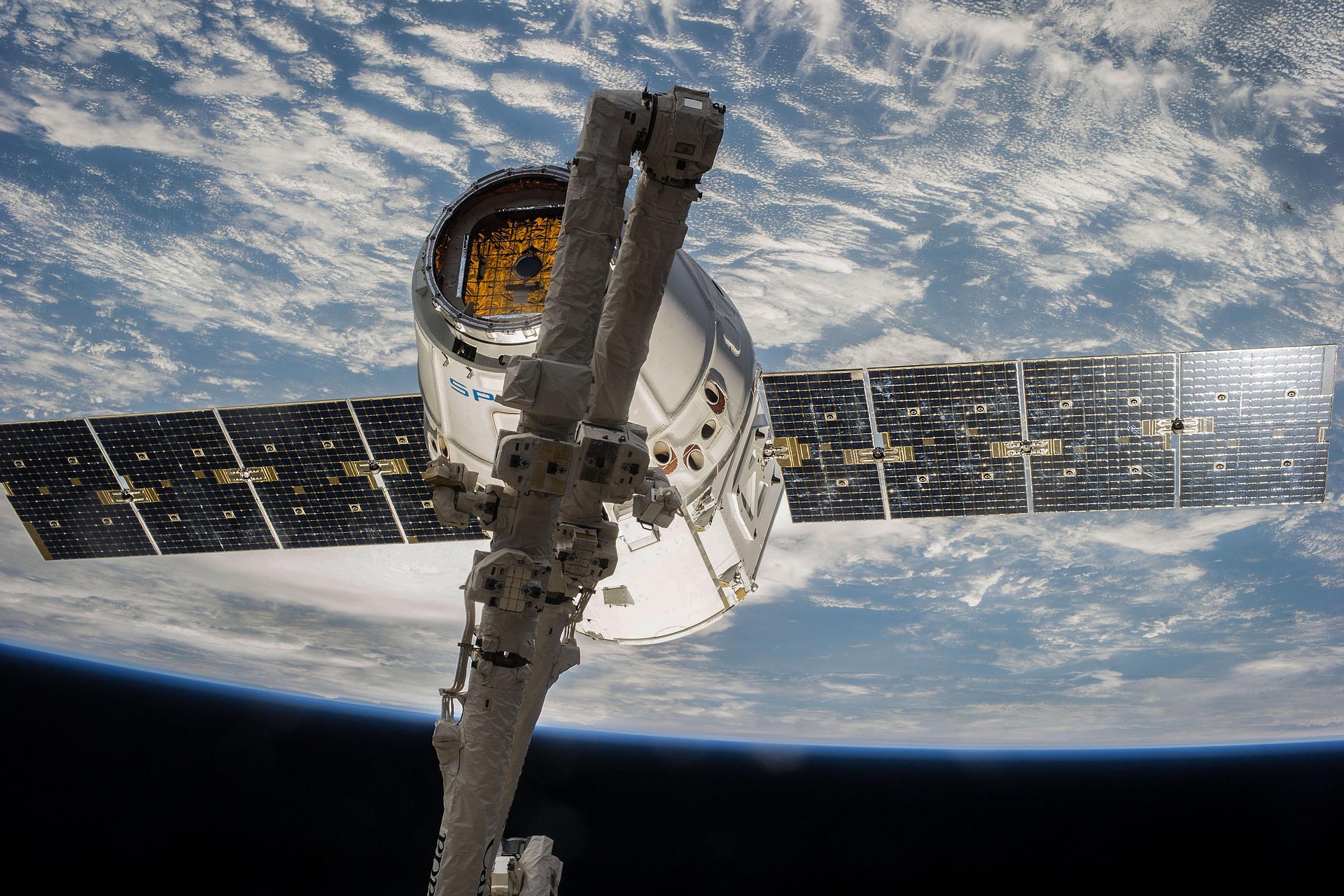 A SpaceX Dragon spacecraft connects with the International Space Station above Earth’s horizon, illustrating how advanced technology strengthens communication across vast distances.