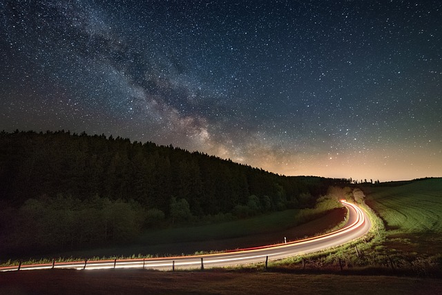 Milky Way over a mountain road with light trails, illustrating the journey toward brilliant communication.